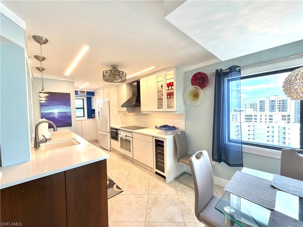 Open-concept living area showcasing tile flooring, soft blue accent walls, and modern ceiling fan