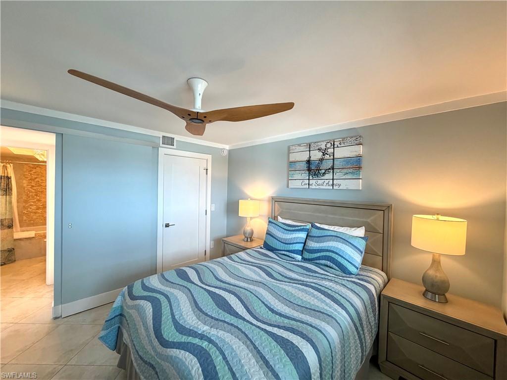 Expansive window with water scenery, crown molding, ceiling fan, and tile flooring