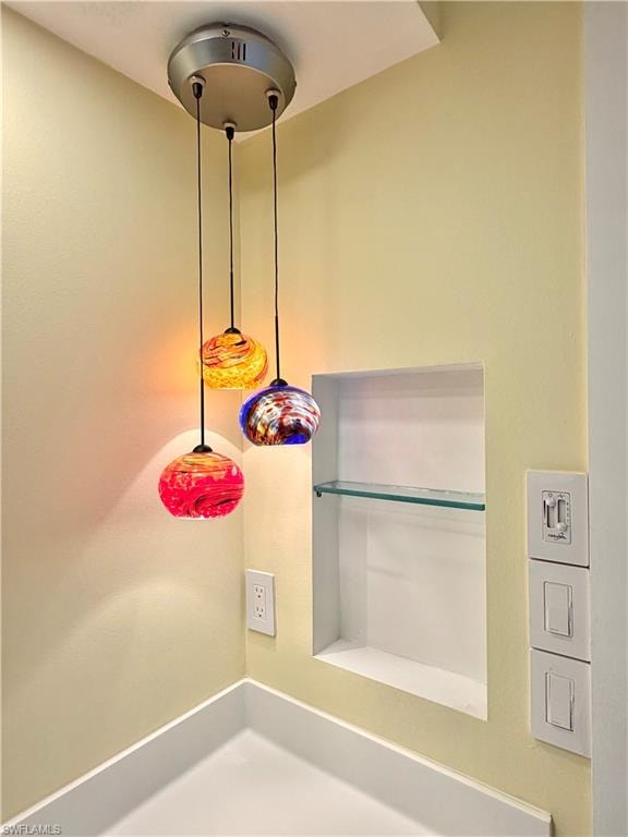 Spa-inspired ensuite bathroom featuring a large framed mirror, white vanity with integrated sink, polished chrome faucet, glass art pendant lighting, tile flooring, and direct access to the primary bedroom suite