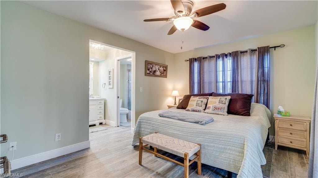Bedroom with wood finished floors, a ceiling fan, and ensuite bathroom