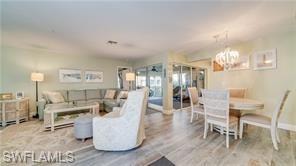 Living room featuring light wood-type flooring and a chandelier