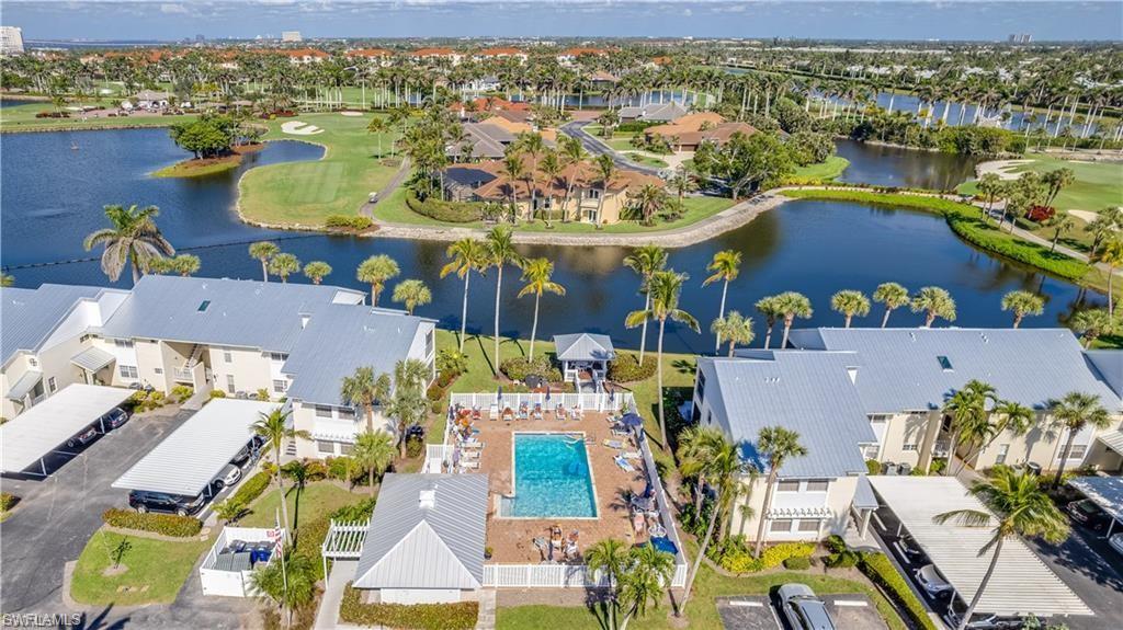 Aerial view of residential area featuring a nearby body of water and a local golf course