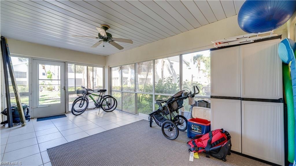 Workout room with tile patterned flooring, wooden ceiling, a ceiling fan, and plenty of natural light
