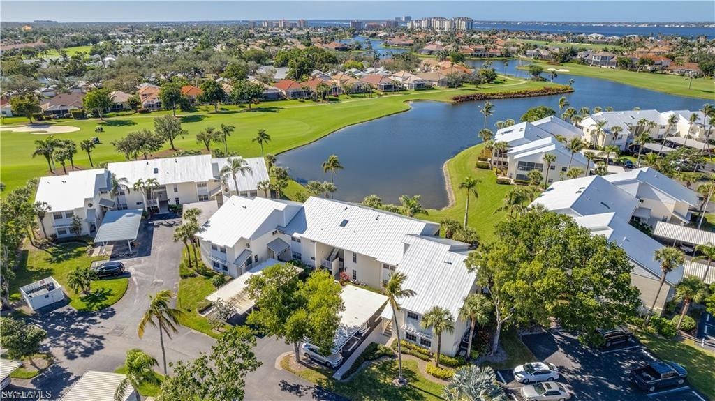 Aerial view of residential area featuring a golf club and a large body of water