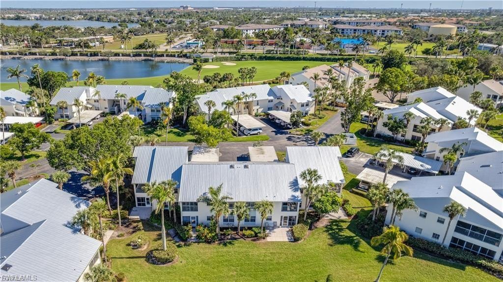 Aerial perspective of suburban area featuring a local golf course and a large body of water