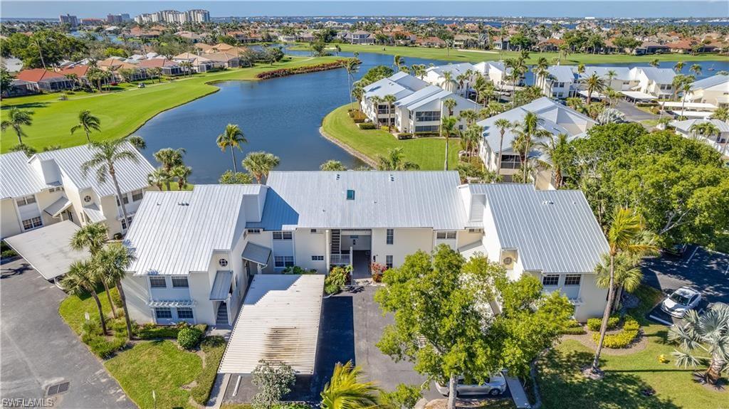 Aerial view of residential area with a golf club and a nearby body of water
