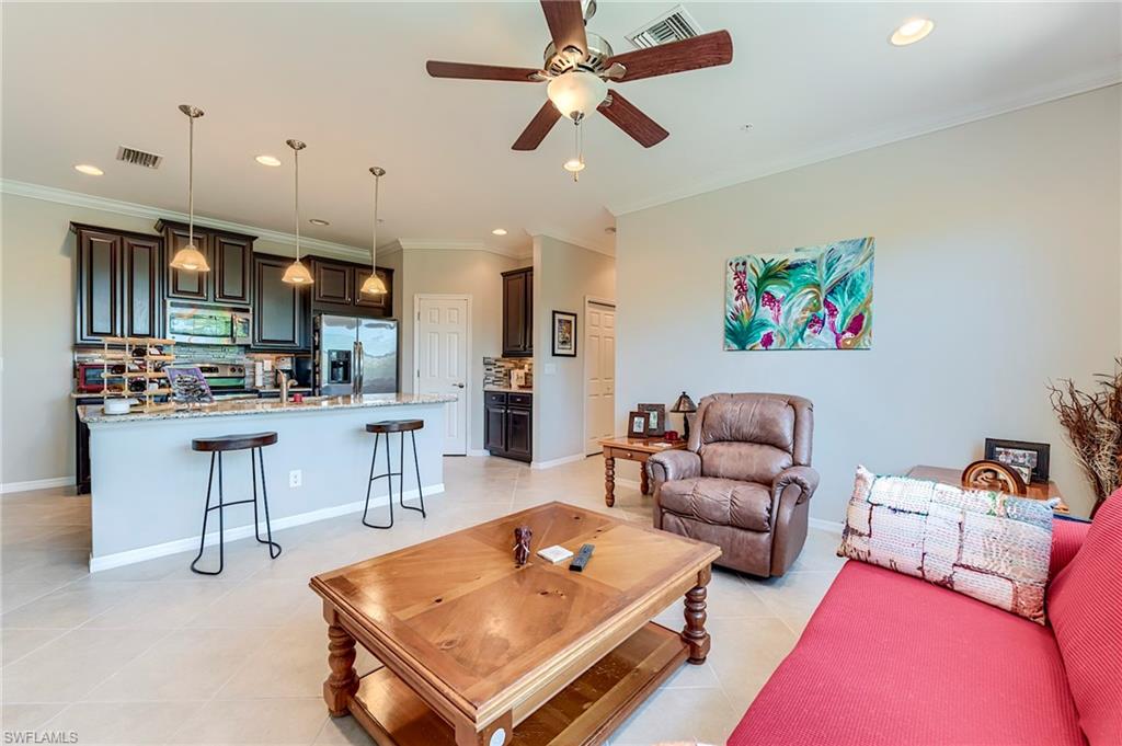 Living room with ornamental molding, ceiling fan, recessed lighting, and light tile patterned floors