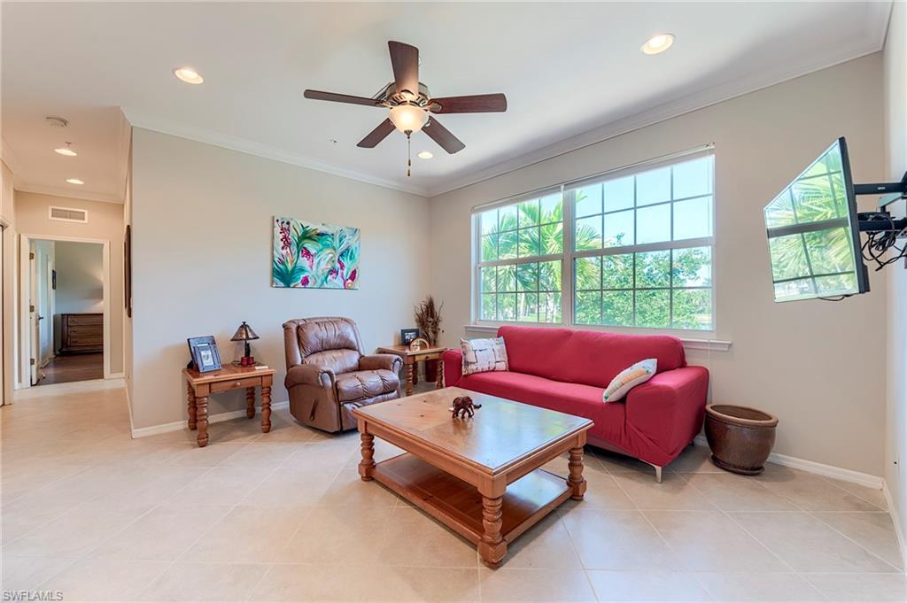 Living area with ornamental molding, a ceiling fan, recessed lighting, and light tile patterned floors