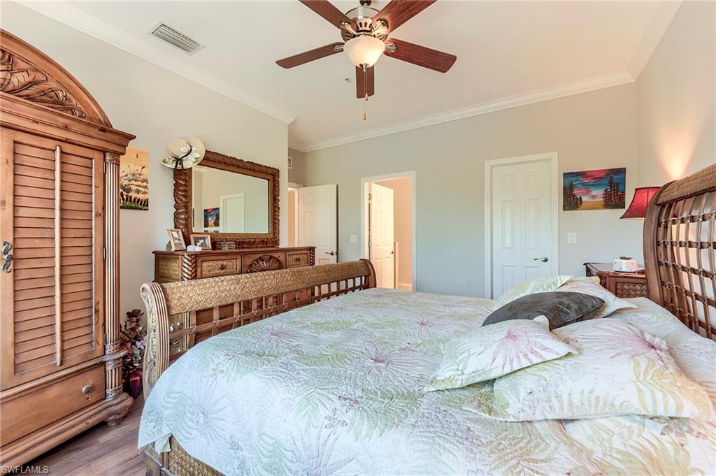 Bedroom featuring ornamental molding, ceiling fan, and wood finished floors