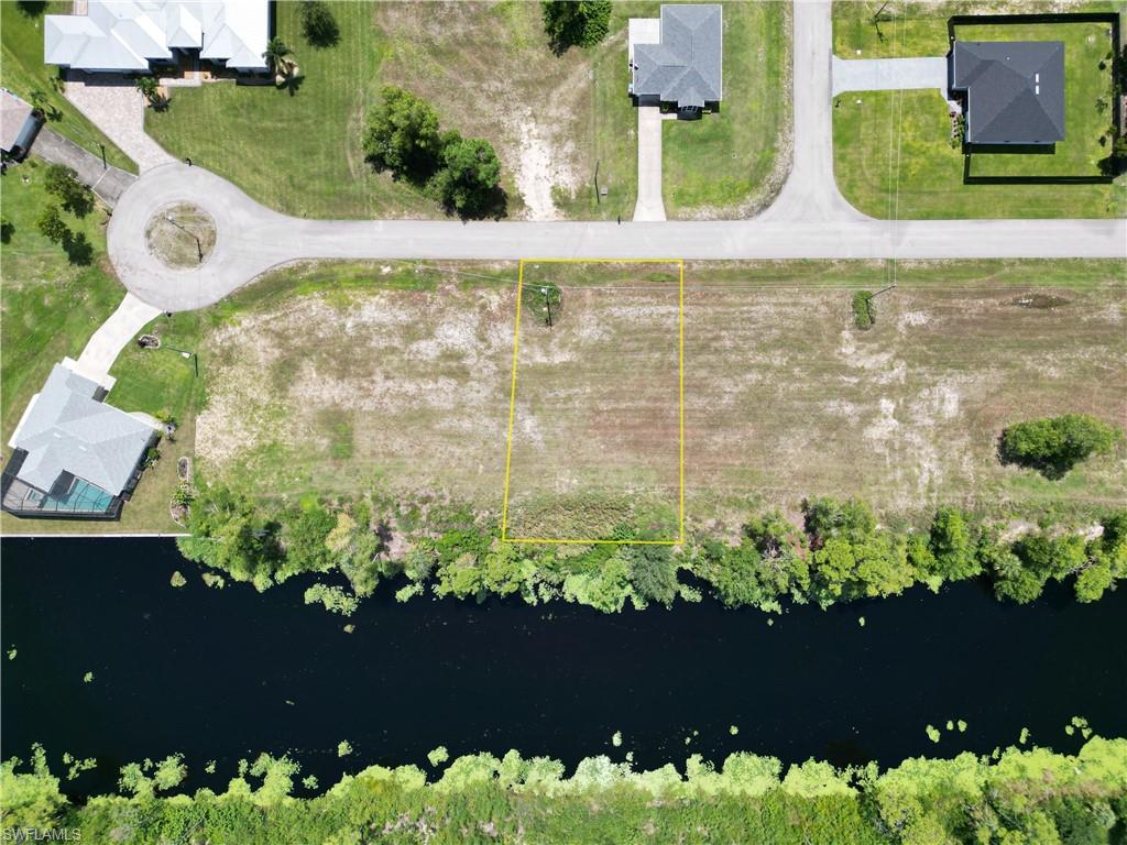 Birds eye view of property with a water view