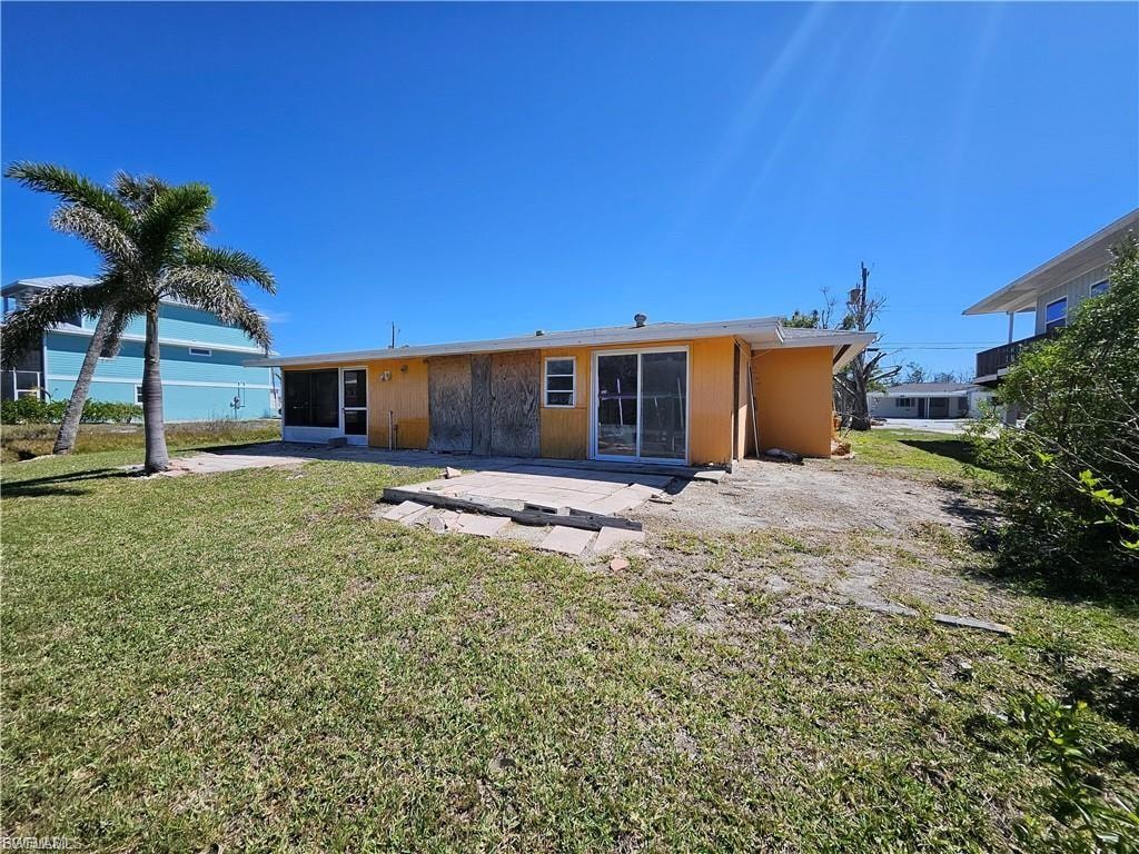 Rear view of property with a yard and a patio