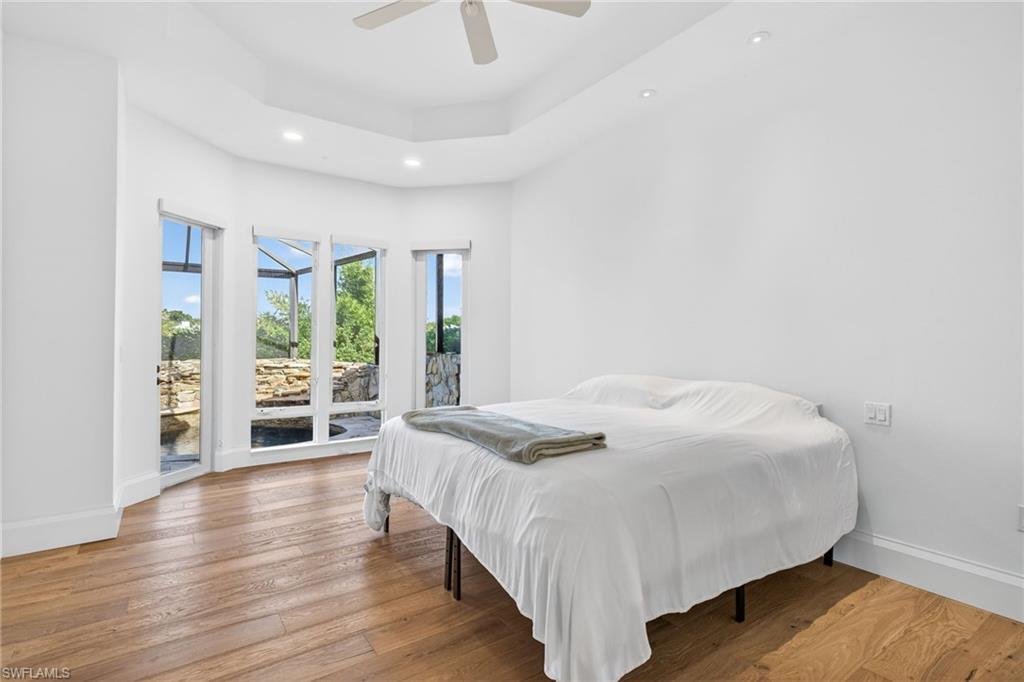 Bedroom with access to exterior, recessed lighting, light wood-style flooring, a ceiling fan, and a sunroom