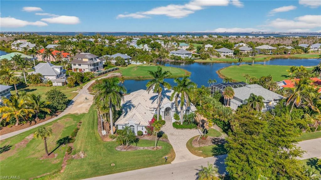 Aerial view of property's location with nearby suburban area, a nearby body of water, and a local golf course