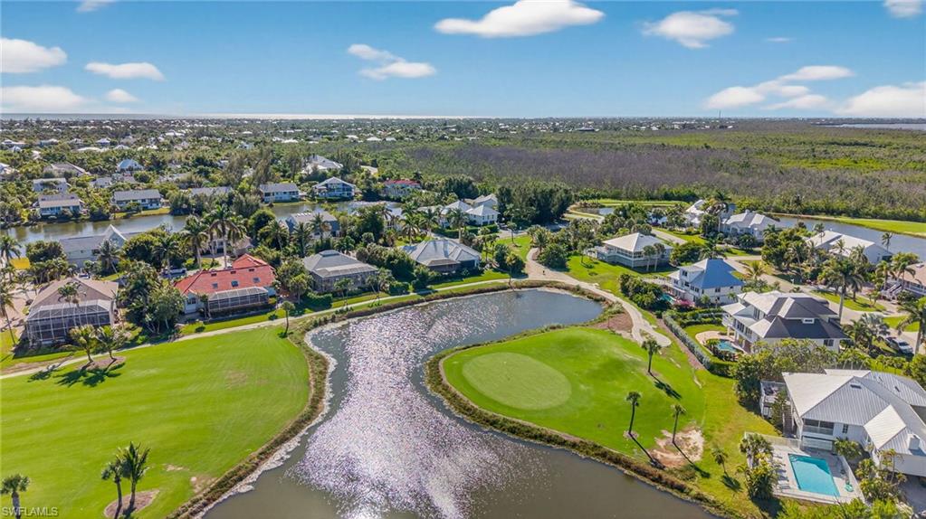 Aerial perspective of suburban area with a large body of water and a golf course