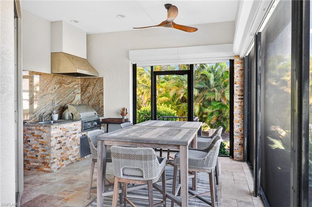 Dining room featuring stone tile flooring, a ceiling fan, and a textured wall