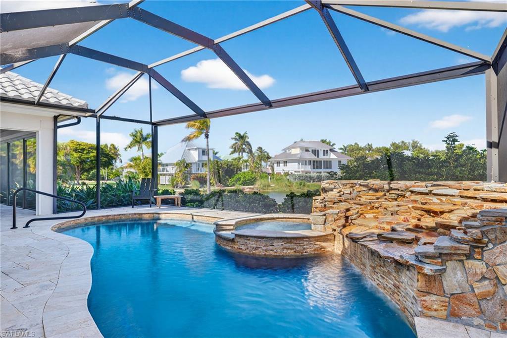 View of swimming pool with a sunroom, a lanai, a patio area, and a pool with connected hot tub
