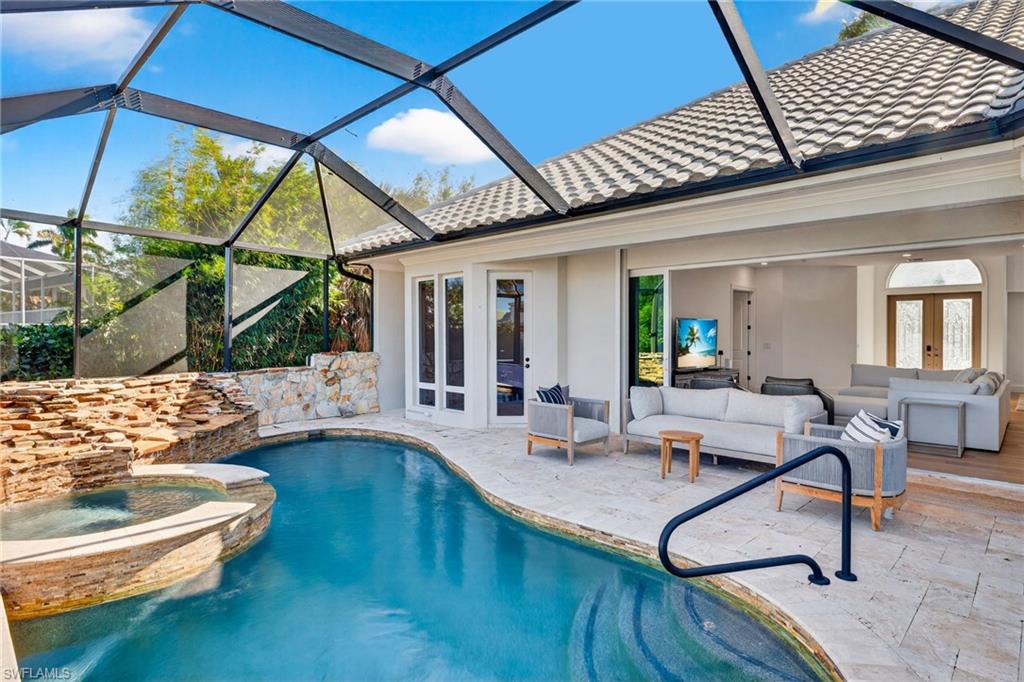 View of pool featuring a sunroom, a patio, a pool with connected hot tub, and french doors