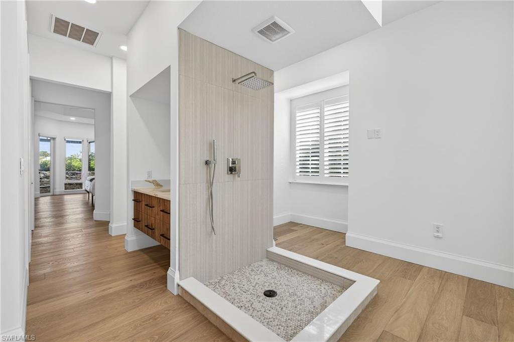 Bathroom featuring vanity, walk in shower, light wood-style floors, and recessed lighting