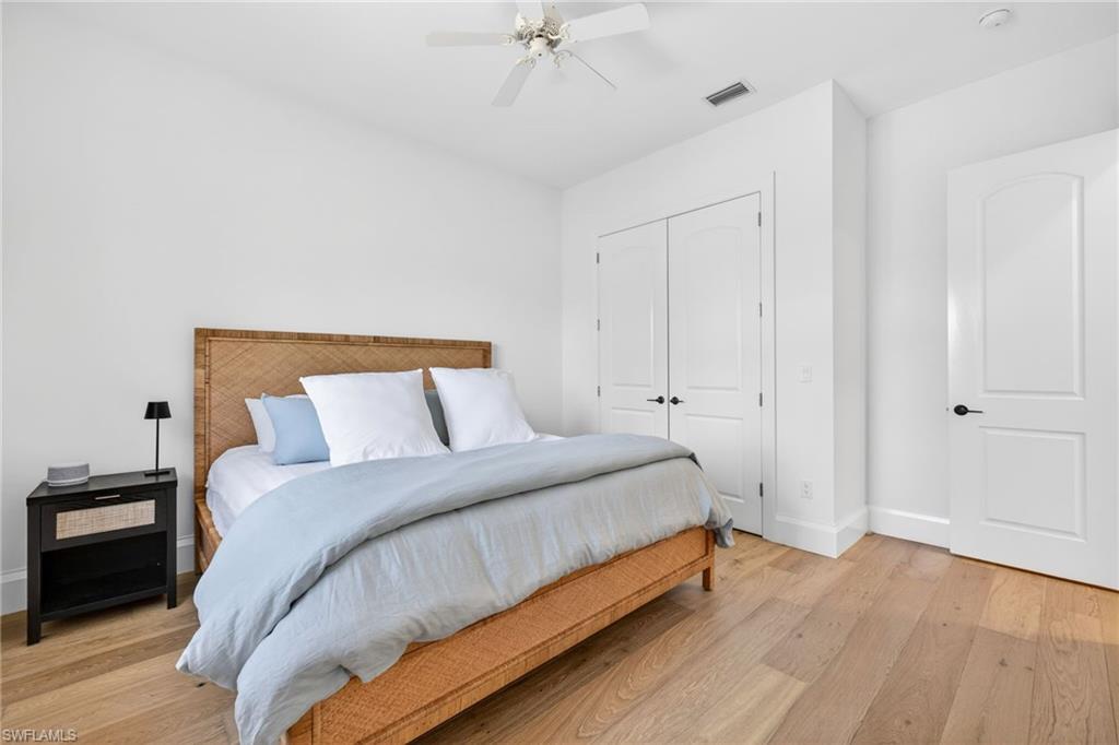 Bedroom featuring ceiling fan, a closet, and light wood finished floors