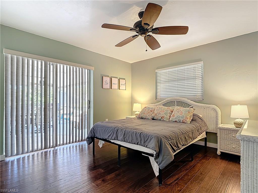 Bedroom with dark wood-type flooring, access to outside, and a ceiling fan