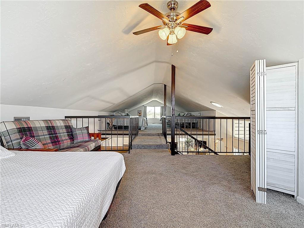 Carpeted bedroom with a textured ceiling and vaulted ceiling