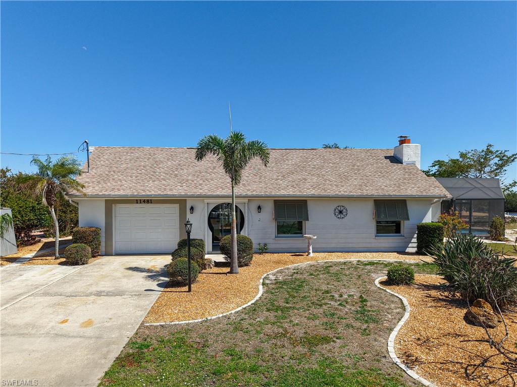 Ranch-style home with roof with shingles, a garage, concrete driveway, stucco siding, and a chimney