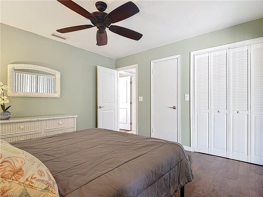 Bedroom featuring dark wood-type flooring, a closet, and a ceiling fan