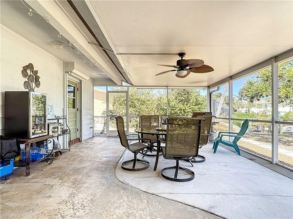 Sunroom / solarium featuring ceiling fan, healthy amount of natural light, and outdoor dining area