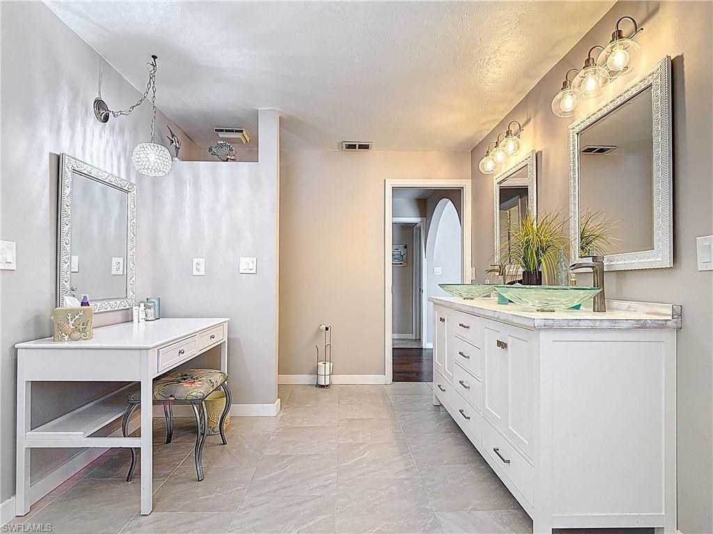 Full bath with double vanity and a textured ceiling