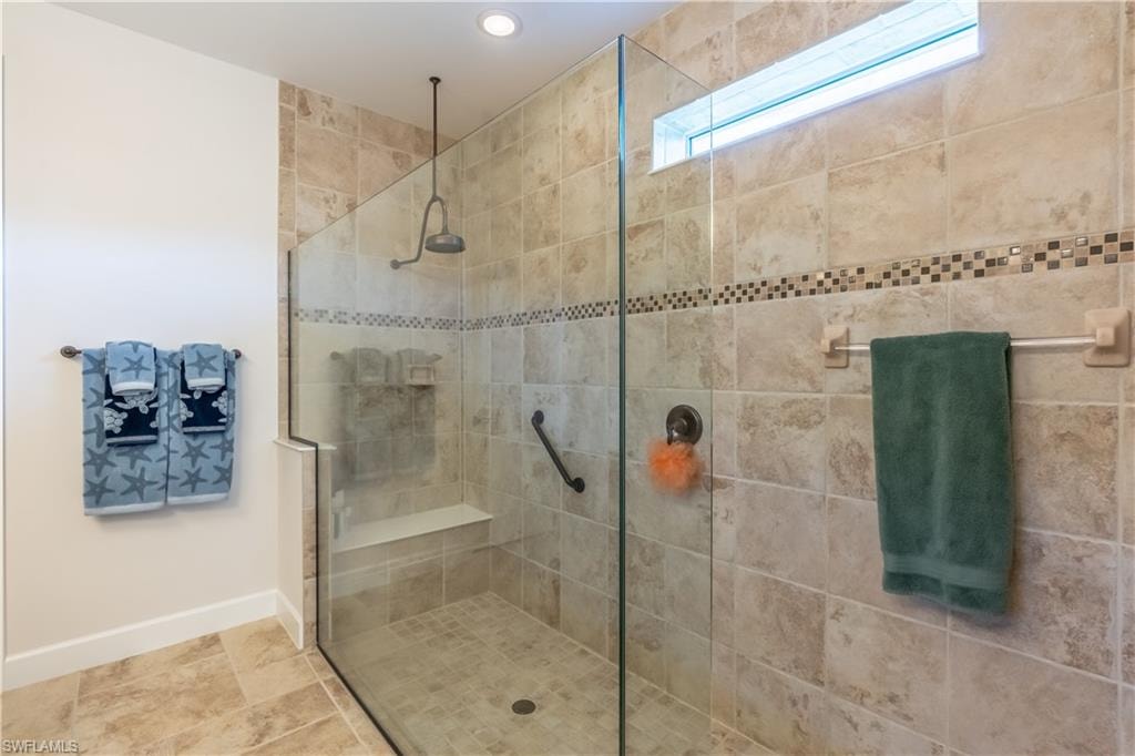 Full bath with walk in shower and baseboards