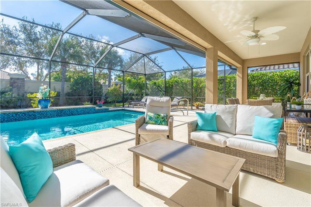Outdoor pool with outdoor lounge area, a patio area, glass enclosure, and a sunroom