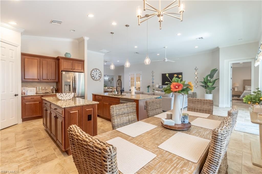Dining area with ornamental molding, a chandelier, recessed lighting, stone tile flooring, and ceiling fan
