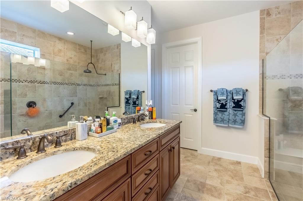Bathroom with tiled shower and double vanity