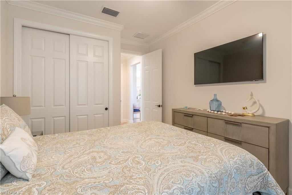Bedroom with crown molding and a closet