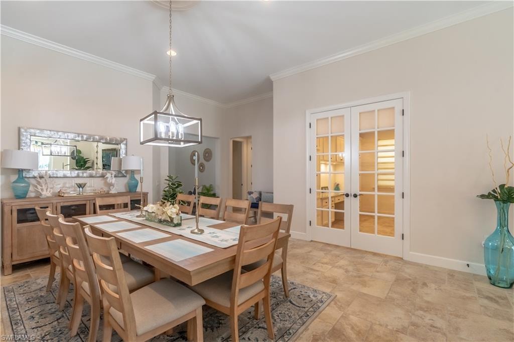 Dining area with french doors, ornamental molding, and a chandelier