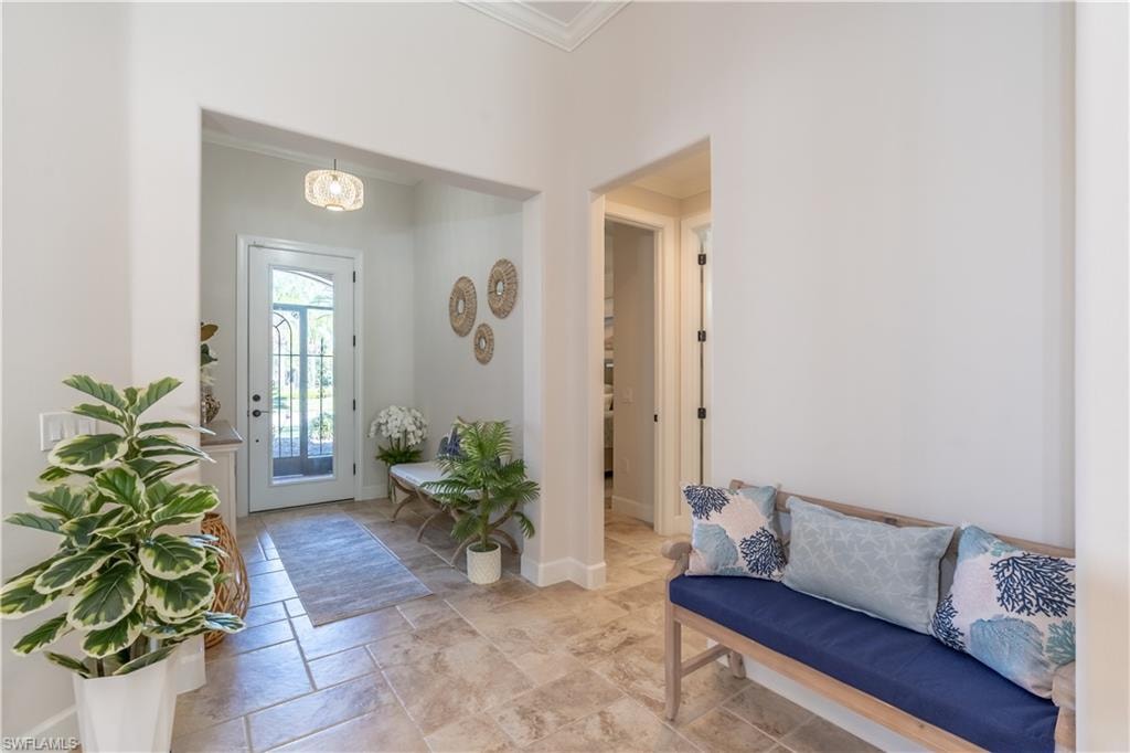 Entryway with crown molding and stone tile flooring