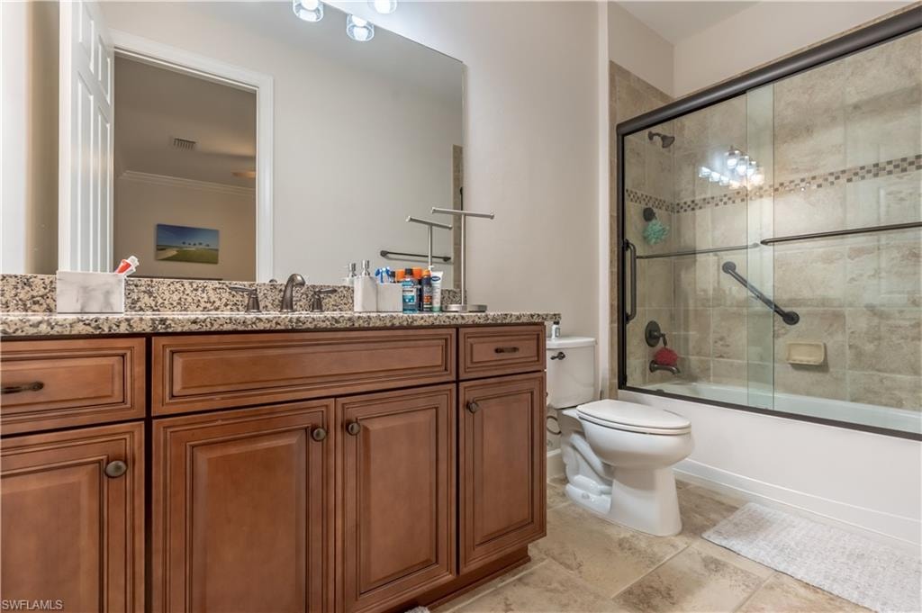 Full bath with vanity and bath / shower combo with glass door