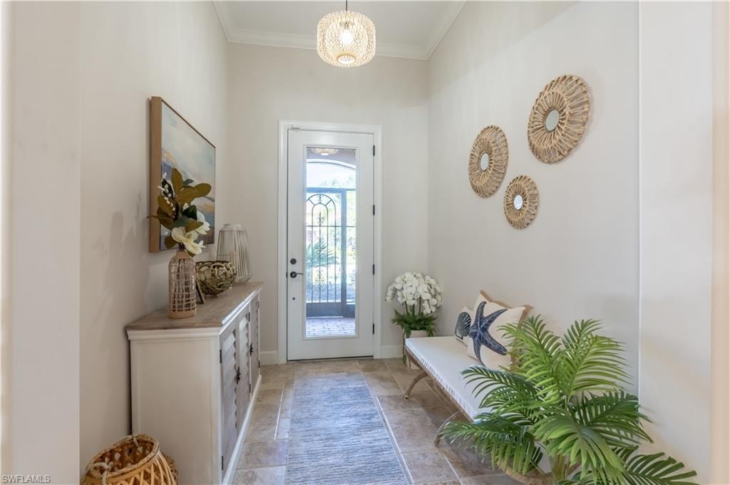 Doorway featuring ornamental molding and baseboards