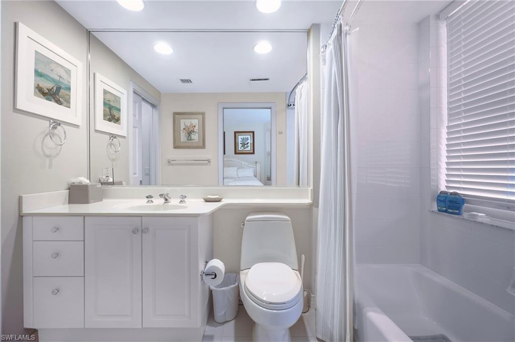 Full bathroom featuring vanity, shower / bath combo, and toilet