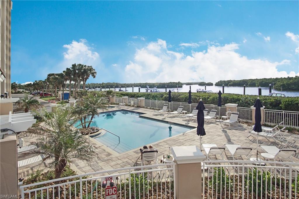 View of swimming pool featuring a water view and a patio area