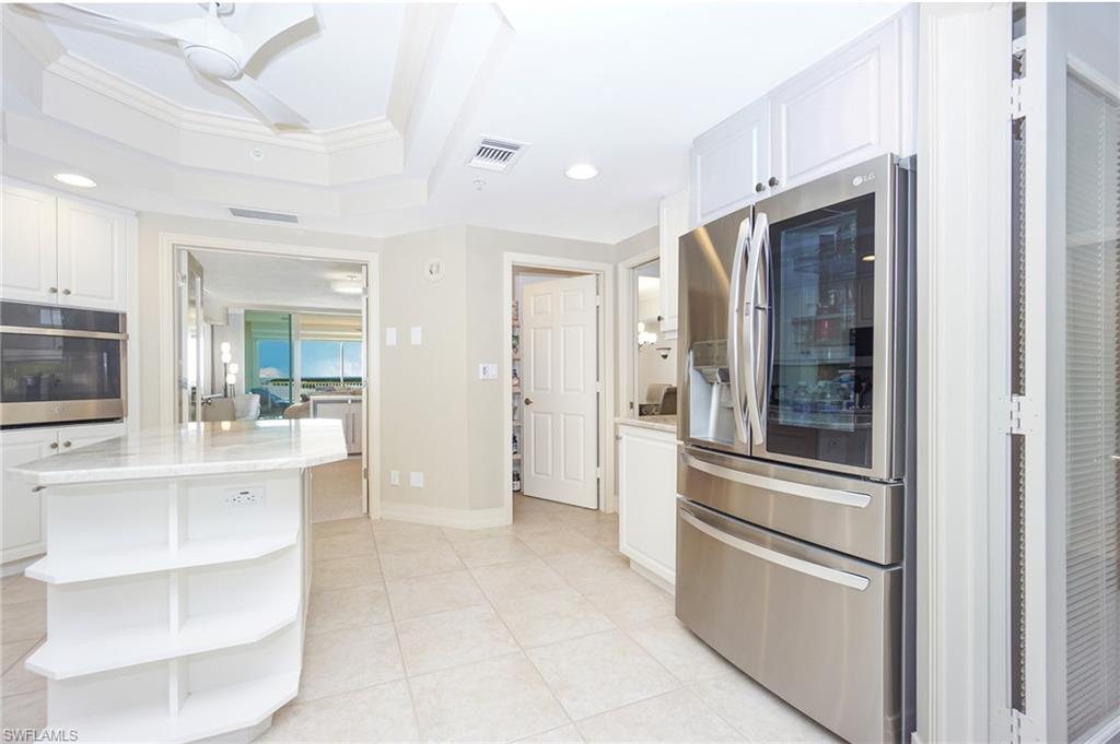 Kitchen featuring crown molding, stainless steel appliances, a kitchen island, and white cabinets