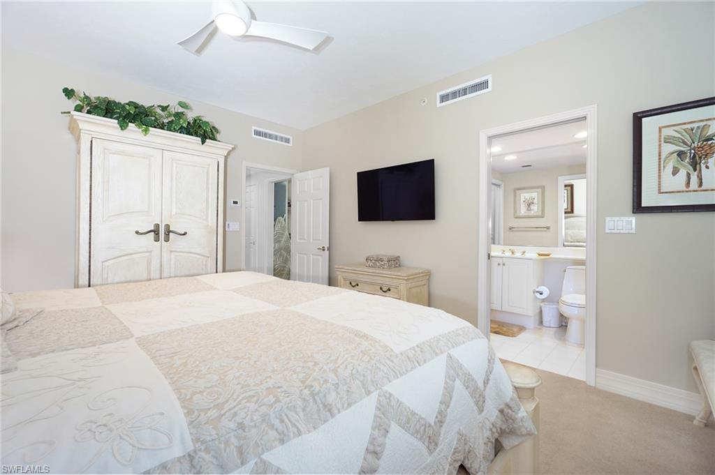Bedroom with ceiling fan, light colored carpet, ensuite bath, and a closet