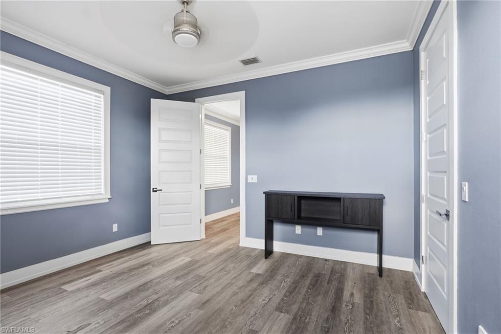 Unfurnished bedroom featuring crown molding, wood finished floors, and ceiling fan