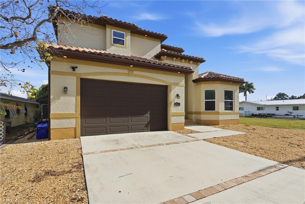 Mediterranean / spanish-style house with concrete driveway, a garage, stucco siding, and a tile roof