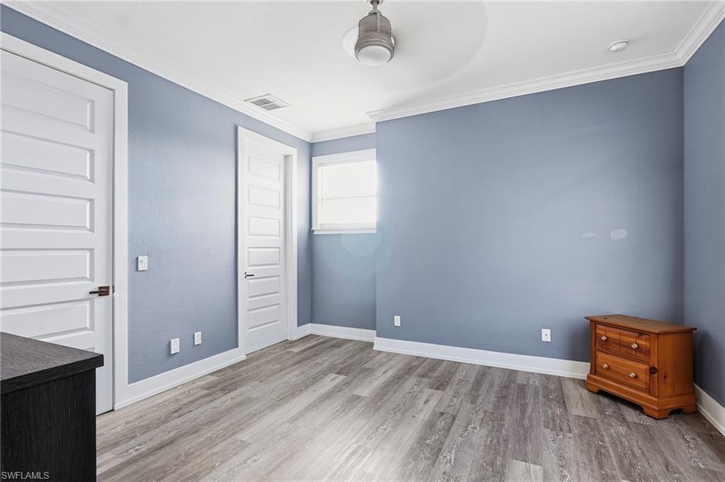 Unfurnished bedroom featuring ornamental molding, light wood-style flooring, and a closet