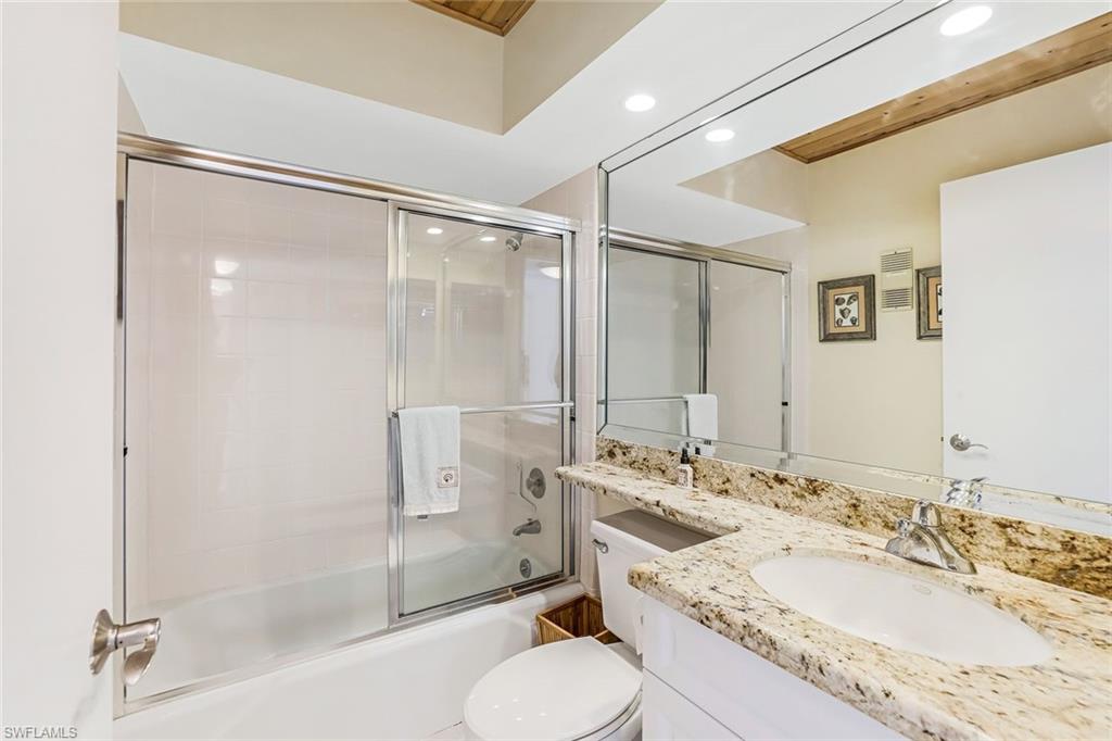 Bathroom with vanity, combined bath / shower with glass door, and recessed lighting