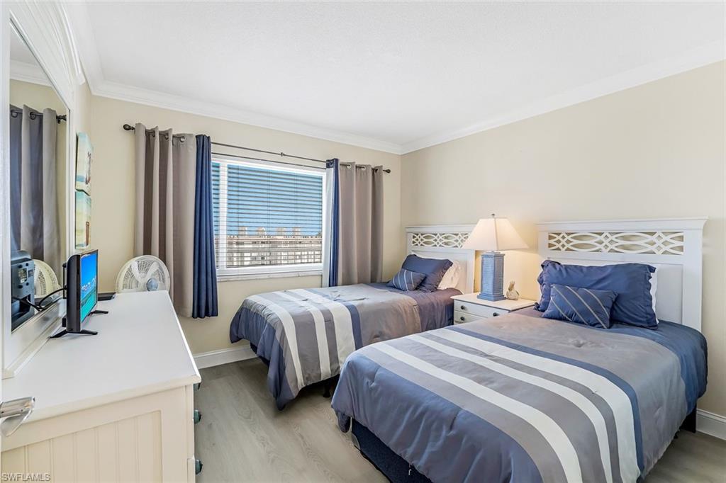 Bedroom featuring light wood finished floors and ornamental molding