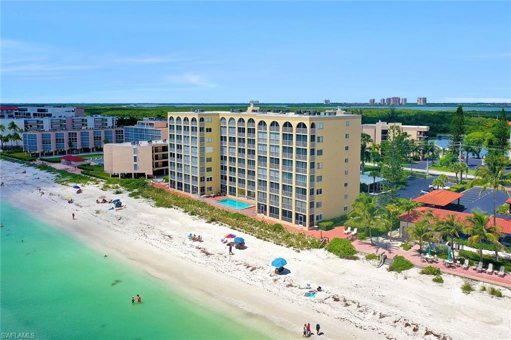 View of apartment building / complex with view of water and beach
