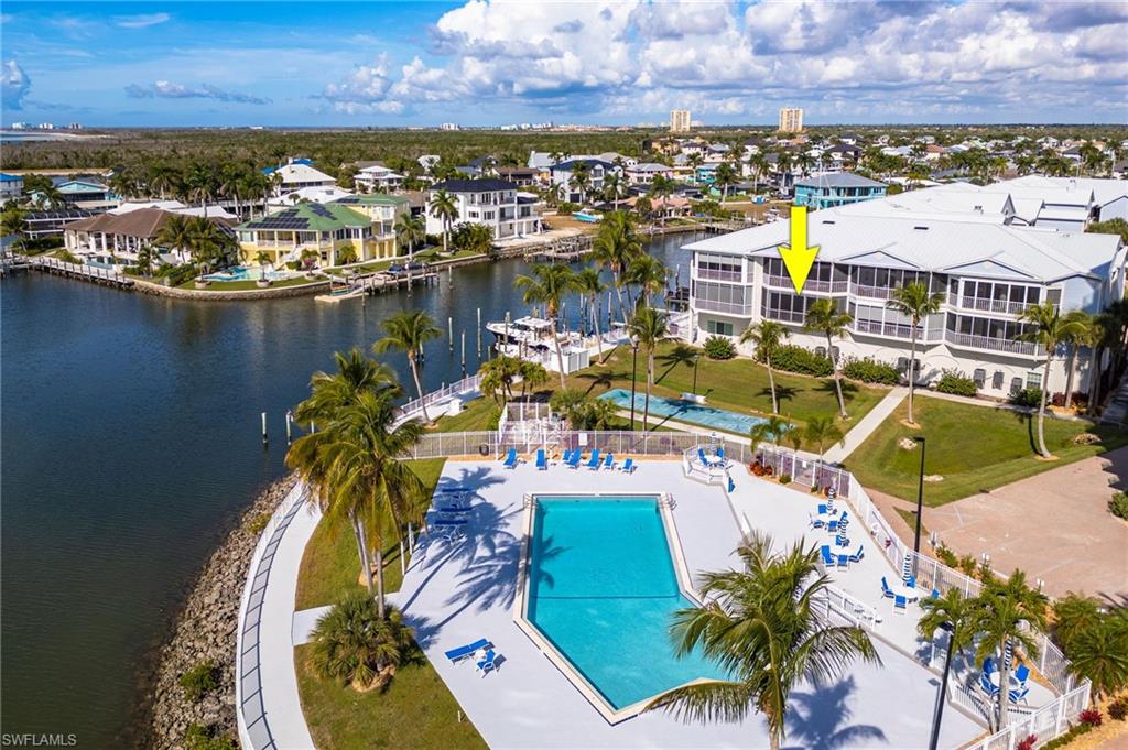 Drone / aerial view of a pool and a nearby body of water