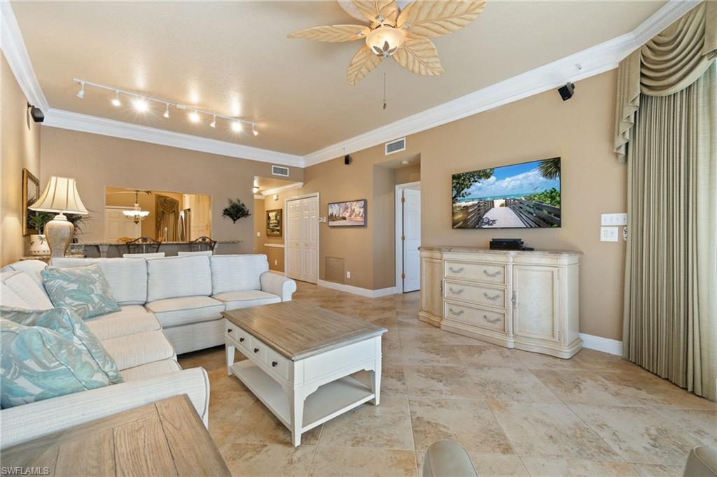 Living room with crown molding, a ceiling fan, and track lighting